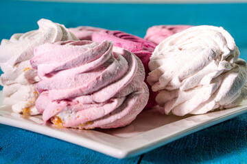 Sweet dessert  zephyr. Marshmallows on blue wooden background