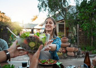 Fototapeta premium Salad, smile and woman in group, outdoor and gathering for reunion with friends, backyard and eating. House, hands and bowl of food in weekend, yard and party for vegan, hungry and brunch for people