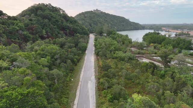 Aerial footage of a paved road along the sea at sunrise in Besut District, Terengganu, Malaysia