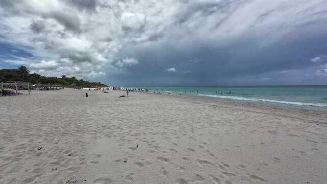 Crowd of people on the sandy beach of Varadero town on a cloudy daytime in Hicacos Peninsula, Cuba