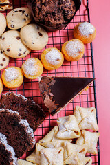 Table with various cookies, pound cake, cake slices, muffins and sweets.