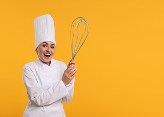 Naklejka premium Happy pastry chef with big whisk on orange background. Space for text
