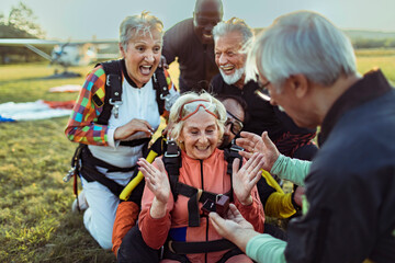 Senior man proposing to woman after skydiving with friends