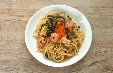 spicy stir fried spaghetti slice squid and shrimp with chili and basil leaf topping shrimp egg in sauce on plate 