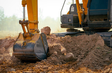 Closeup bucket of backhoe digging the soil at construction site. Crawler excavator digging on demolition site. Excavating machine. Earth moving equipment. Excavation vehicle. Construction business. © Artinun