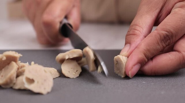 Female Hand SLicing Bakso or Beef Meatballs 