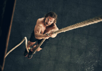 Body, exercise and rope climbing with man in gym from above for challenge, performance or workout....