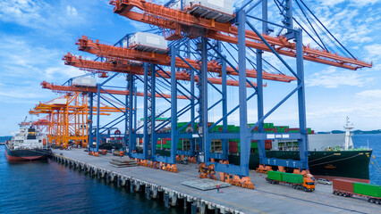 crane loading cargo container from truck to container ship in the international terminal logistic sea port concept freight shipping by ship. industry transportaion