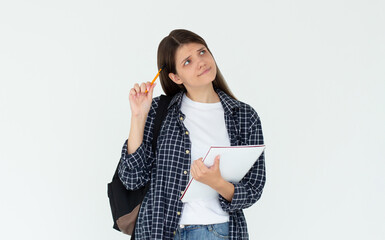 Cute woman thinking about smth with notepad. Young brunette student girl is thoughtful with pen in hand on white background