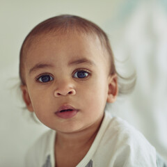 Cute, portrait and boy baby in home for growth, learning or cognitive motor skills for development. Sweet, adorable and face of calm infant or toddler in nursery room for early childhood in house.