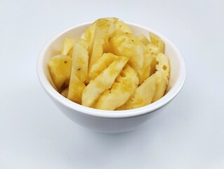 Fresh pineapple pieces in bowl isolated on white background 