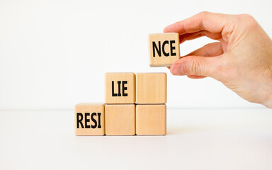 Resilience symbol. Concept word Resilience on beautiful wooden cubes. Businessman hand. Beautiful white background. Business resilience concept. Copy space.