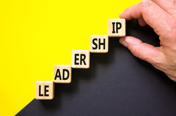 Leadership symbol. Concept word Leadership on beautiful wooden cubes. Beautiful yellow and black background. Businessman hand. Business leadership concept. Copy space.