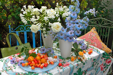 Flowers and fruit still life on a table outdoors