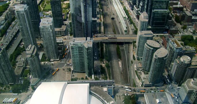 Breathtaking aerial perspective of downtown Toronto and a stadium alive with baseball fans. The summer day highlights the city dynamic energy as crowds gather to enjoy the match.