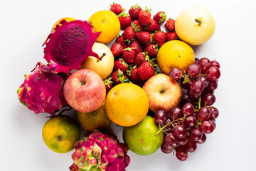 Various ripe fruits and berries in the background, top view