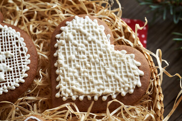 Homemade gingerbread Christmas cookie in the shape of a heart decorated with white icing in a basket