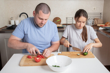 Teenager daughter and father cooking in the kitchen, preparing breakfast with joy, ingredient preparation.
