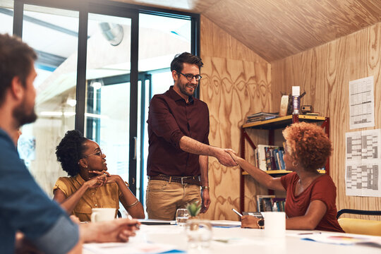 Office, business people and shaking hands in meeting for welcome, introduction and onboarding with smile. Team, employees and manager of marketing agency with client for handshake, deal or thank you
