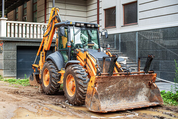 Construction grader tractor with bucket at construction site.