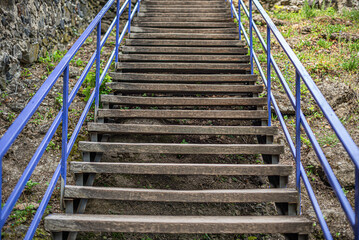 Wooden staircase with iron handrails.