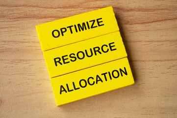 Top view of Optimize Resource Allocation text on yellow wooden blocks. Business improvement concept