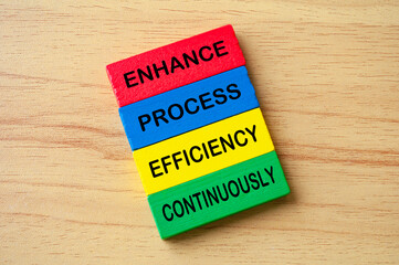 Top view of Enhance Process Efficiency Continuously text on multicolored wooden blocks. Business improvement concept