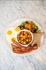 Breakfast plate with egg and bacon.