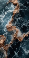Aerial view of rocky coast with coppery tones and rough waves
