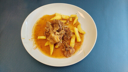 Lamb in chilindrón sauce with shredded potatoes and parsley