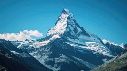 Top view of the snow-capped Matterhorn mountain, standing tall amidst the rugged Swiss Alps with a clear blue sky.