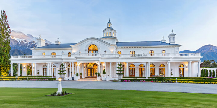 White luxury palatial estate home in the countryside. New Zealand landscape setting, fictitious property
