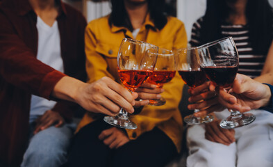 Happy friends making a toast with beer before eating pizza in a shared apartment.