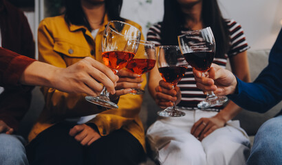 Happy friends making a toast with beer before eating pizza in a shared apartment.