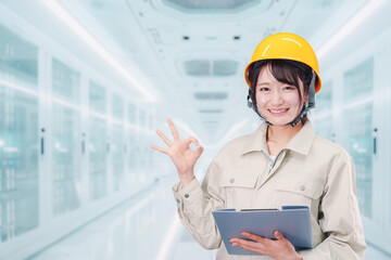 データセンターのサーバールームで働く作業服姿の女性