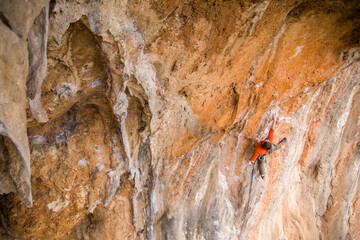 A rock climber ascends to the summit via a difficult route.
