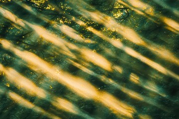 Captivating abstract forest pattern with golden light and green hues, creating a serene and enchanting atmosphere.