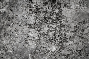Weathered concrete surface with dark patches. A close-up of a weathered concrete surface, featuring dark patches and a rough texture.