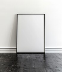 Empty black frame leaning against a white wall on a dark hardwood floor.