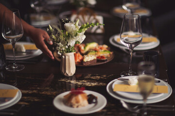 Hands decorate the table. decorators decoration with fresh flowers on served tables. Decoration Details.