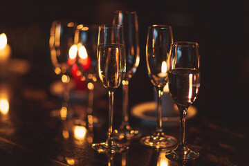gasses of champagne in the dark with candles light. alcohol cocktails on a party. Party and holiday...
