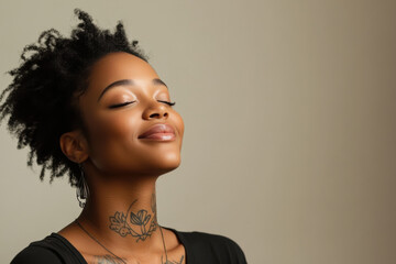 A close up of a tattooed black woman's face with her eyes closed