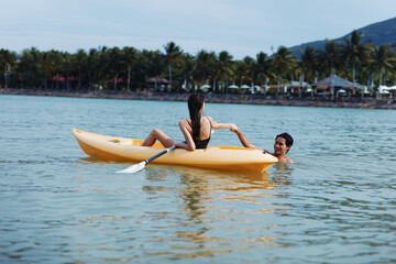 Kayaking Bliss: A Carefree Couple Paddling in Beautiful Sunset over Tropical Lake