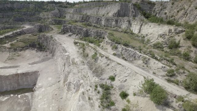 The video presents a captivating aerial view of a rocky quarry. The quarry is filled with , jagged rocks and that have been formed over millions of years. The quarry is a popular spot for rock