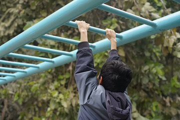 Child playing on monkey bars in an outdoor playground