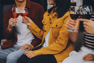 Happy friends making a toast with beer before eating pizza in a shared apartment.