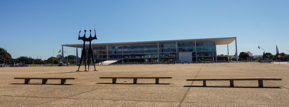 Brasilia, Brazil - Jul 22 2024: sculpture Dois Candangos and Planalto Palace, headquarters of the Presidency of Brazil