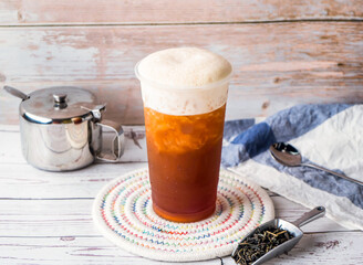 iced milk Black Tea with sugar pot and spoon served in disposable glass isolated on table side view of hong kong tea