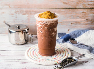 Iced Chocolate Wheat Germ Milk Tea with sugar pot and spoon served in disposable glass isolated on table side view of hong kong tea