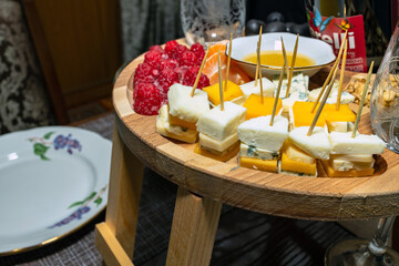 Set of cheeses with grapes and raspberries. cheese plate in restaurant for wine and aperitif with sage.